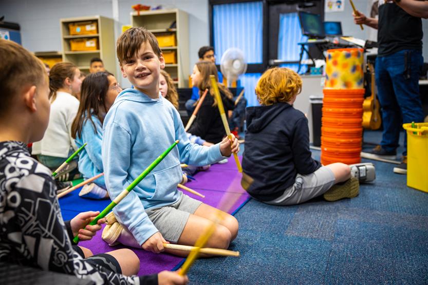 Students play drums in music class
